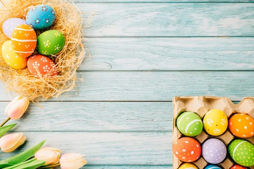 Happy Easter Day Concept. Flat lay of holiday banner background web design easter eggs in brown nest on blue wooden background with empty copy space, celebration greeting card, overhead, template