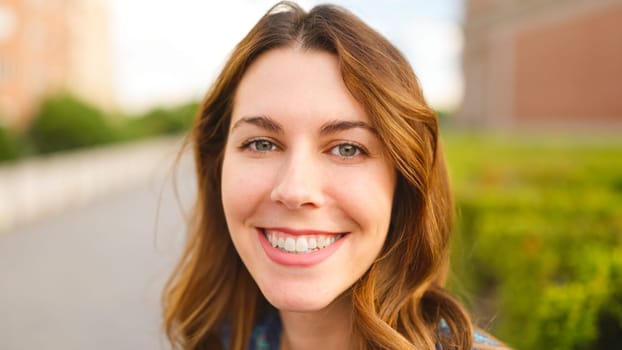 Close up view of a beauty woman with blue eyes looking to the camera and smiling