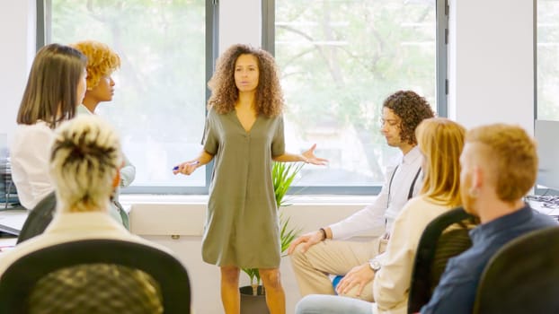 Female manager scolding employees seriously in a coworking space