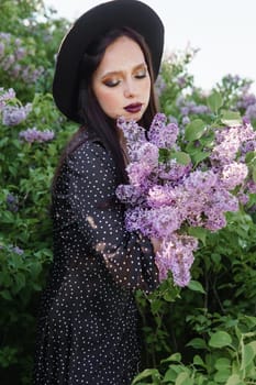 A fashionable girl with dark hair, a spring portrait in lilac tones in summer. Bright professional makeup