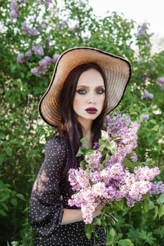 A fashionable girl with dark hair, a spring portrait in lilac tones in summer. Bright professional makeup