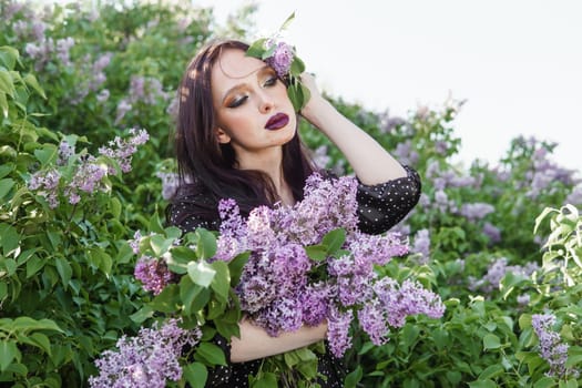 A fashionable girl with dark hair, a spring portrait in lilac tones in summer. Bright professional makeup