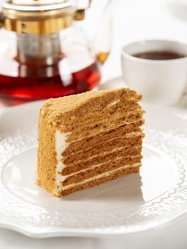 Slice of layered honey cake selective focus. Perfect piece of layered honey cake in restaurant bokeh background. Traditional Russian layer cake Medovik made with honey