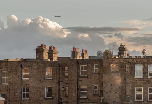 London, UK - Feb 18, 2024 - Rear view of urban brick apartment buildings and old houses in london with sky background at evening. Exterior of The Windows and decoration of walls, Space for text, Selective focus.