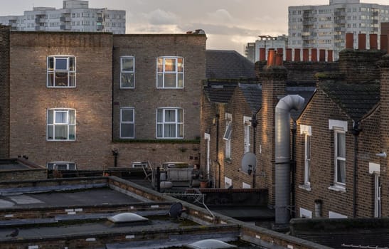 London, UK - Feb 18, 2024 - Rear view of urban brick apartment buildings and old houses in london with sky background at evening. Exterior of The Windows and decoration of walls, Space for text, Selective focus.