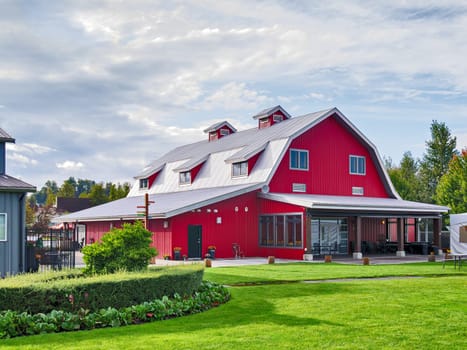 Grosseries production farm building with covered picnic patio and green lawn in front