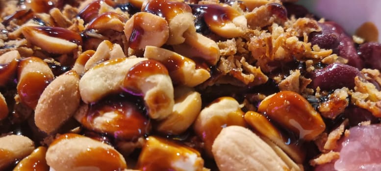 Delicious close-up of homemade peanut brittle with caramelized sugar, nuts, and a crunchy texture, perfect for a sweet indulgent treat or gourmet dessert