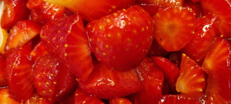 Close-up of vibrant and juicy freshly sliced red strawberries. A healthy and nutritious summer fruit. Perfect as a dessert ingredient. On a natural food background. Showcasing the organic. Ripe