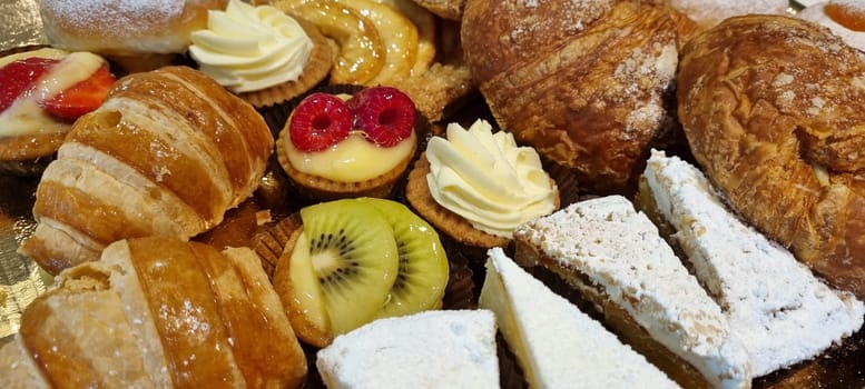 Close-up of a tempting selection of freshly-baked pastries garnished with fruits and cream