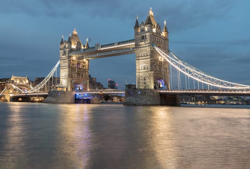London, UK - Feb 15, 2024 - Beautiful scenery view of famous Tower bridge and skyline with reflections in the river thames just after sunset. The illuminated Tower Bridge, Copy space, Selective focus.