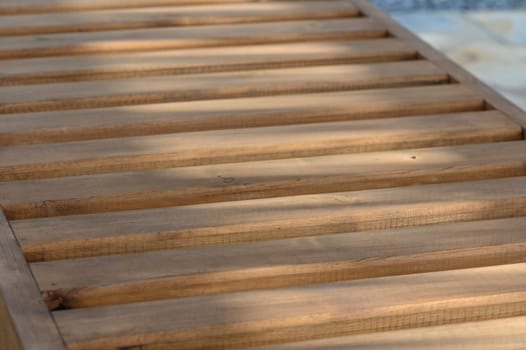 wooden sun loungers in the sun's rays as a background