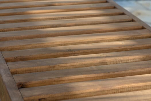 wooden sun loungers in the sun's rays as a background 1