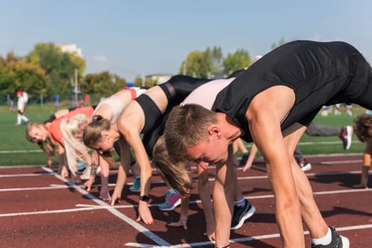 Group of young athlete runnner are training at the stadium outdoors