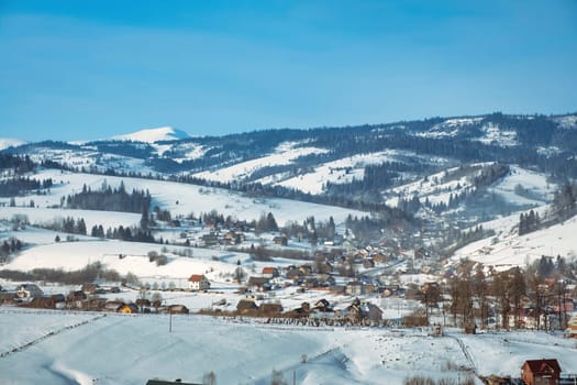 The small village covered in snow, with mountains