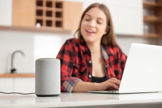 Woman talking to smart speaker. Intelligent assistant in smart home system.