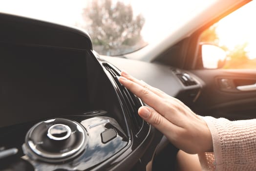 Car air conditioning. Woman checks air conditioning in a car