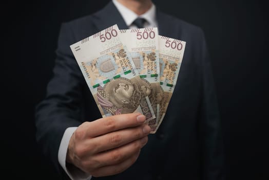 Businessman holds polish money banknotes. Running a business in Poland