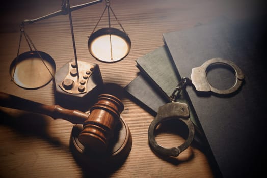 Gavel, weight scale, handcuffs on desk. Law and crime concept