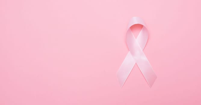 Pink breast cancer awareness ribbon with copy space, pink backgrounnd