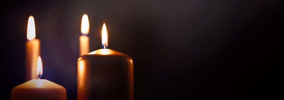 Funeral symbol with burning candle in darkness. Copy space.