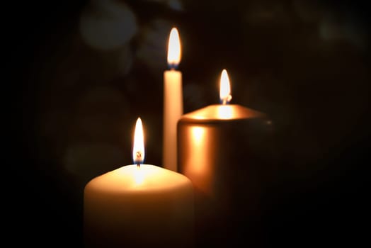 Funeral symbol with burning candle in darkness. Memorial composition