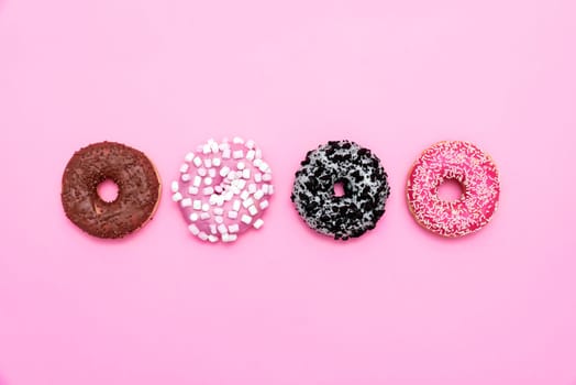 Delicious donut on color background. Mix of multicolored doughnuts, top view