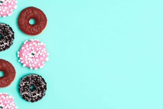 Delicious donut on color background. Mix of multicolored doughnuts, copy space