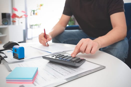 Budget and loan paper in office. Business accounting concept with businessman using calculator.