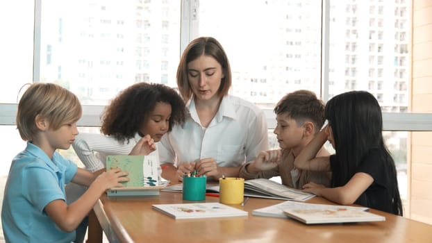 Happy diverse student and smart teacher drawing and coloring by using marker at drawing book. Multicultural smart learner using drawing book while talking to skilled caucasian instructor. Erudition.