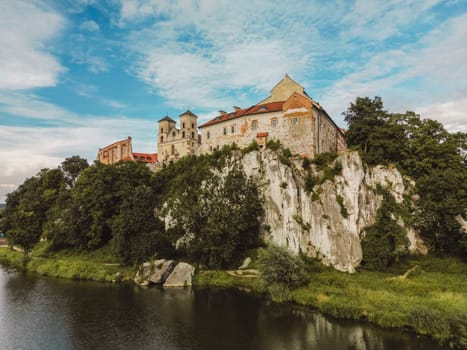 Aerial view of Benedictine abbey of Saints Peter and Paul in Tyniec, Poland. Stone building of medieval catholic monastery, stronghold with towers and church on scenic river bank near Krakow