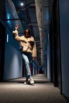 Model with jeans and fur coat in hotel hallway, Spain