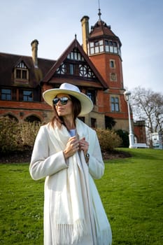 Stylish woman with white coat and hat at the Miramar Palace, San Sebastian