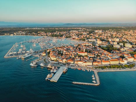 Biograd na Moru, marina aerial view, port with sailing boats and luxury yachts in sunlight. Summer landscape with Old Town houses and blue waters of Adriatic Sea coast, Dalmatia region in Croatia