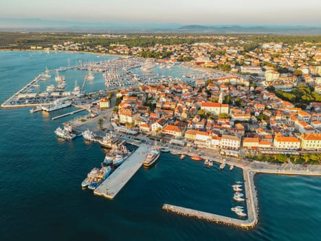 Biograd na Moru, aerial view of marina waterfront with ships and yachts at sunset. Waterfront landscape with port and historic architecture of Old Town, Adriatic Sea coast, Dalmatia region in Croatia