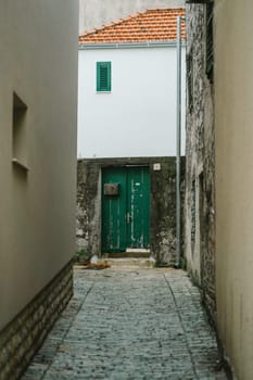 Old narrow street with house facades, entrance doors and retro mailbox, Old Town, Biograd na Moru in Croatia