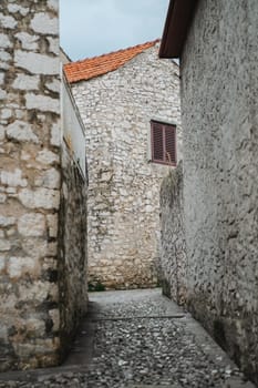 Narrow street between ancient stone houses of Old Town, Biograd na Moru in Croatia