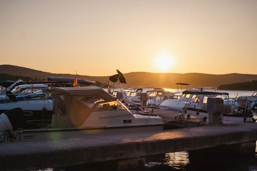 Sunset in Biograd na Moru port of Croatia, many luxury yachts and motor boats at pier in sunlight
