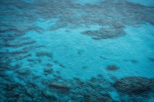 Top view of stones and rocks, ripples in turquoise water of sea in Cape Greco National Park, Cyprus