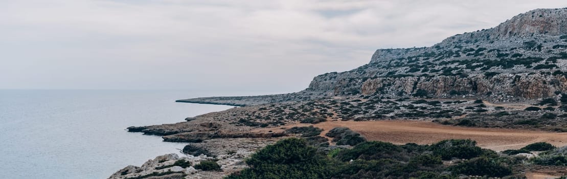 Beautiful panoramic view of Cape Cavo Greco with rocks and grass on empty beach, Cyprus