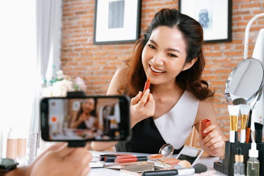 Woman influencer shoot live streaming vlog video review makeup uttermost social media or blog. Happy young girl with cosmetics studio lighting for marketing recording session broadcasting online.