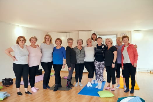 A vibrant community of senior women, guided by their instructor, embraces the enriching journey of yoga, fostering unity, well-being, and a shared commitment to active aging.