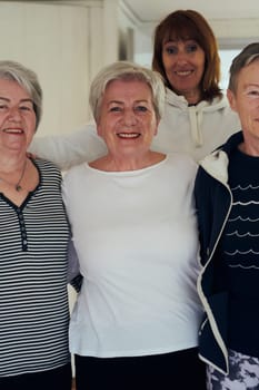 A vibrant community of senior women, guided by their instructor, embraces the enriching journey of yoga, fostering unity, well-being, and a shared commitment to active aging.