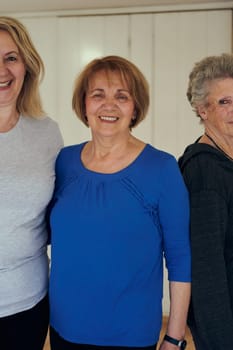 A vibrant community of senior women, guided by their instructor, embraces the enriching journey of yoga, fostering unity, well-being, and a shared commitment to active aging.