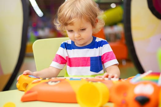 Child playing with colorful toys at the learning center or in kindergarten.