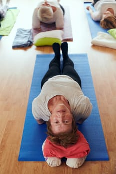 Top view of group of senior women engage in various yoga exercises, including neck, back, and leg stretches, under the guidance of a trainer in a sunlit space, promoting well-being and harmony.