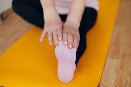 An elderly woman gracefully engages in various yoga poses, stretching her limbs and finding serenity in a modern sunlit space under the guidance of a trained instructor, embodying the essence of active and mindful aging.