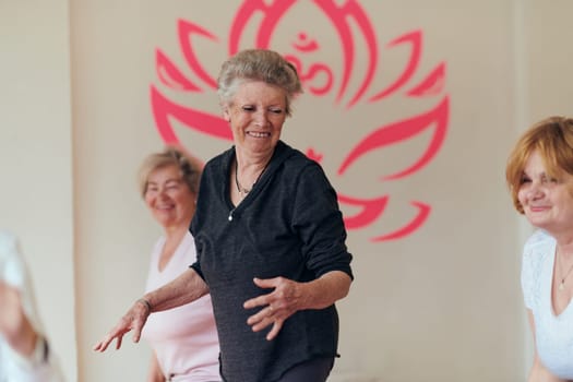 A group of senior women engage in various yoga exercises, including neck, back, and leg stretches, under the guidance of a trainer in a sunlit space, promoting well-being and harmony.