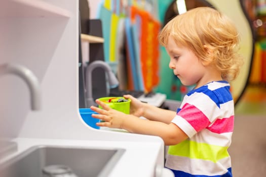 Child playing with colorful toys at the learning center or in kindergarten.