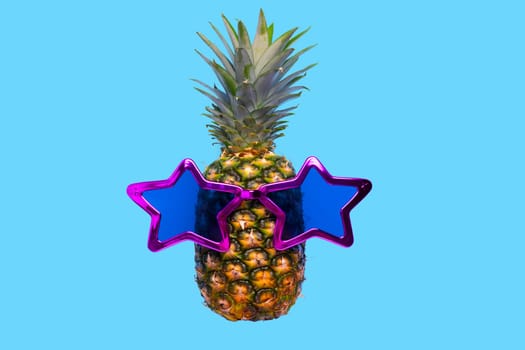 Pineapple with sunglasses on blue background.