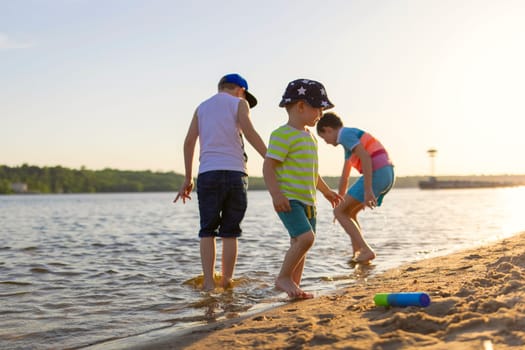 Cute kids having fun on the sandy beach in summer.